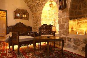 a bedroom with a table and chairs in a room at BEYT NAHRAYN KONAK in Mardin