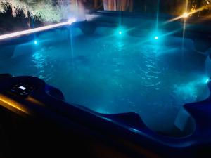 a swimming pool at night with blue lights at Apartamenty Willa NaSkarpie Jacuzzi Sauna Basen in Wisła