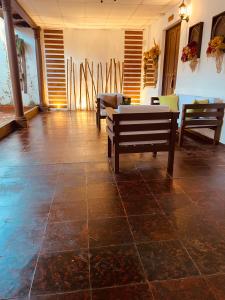 una habitación con dos bancos y una mesa en ella en Casa Hotel Santa Lucia en Suchitoto
