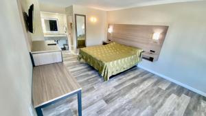 a hotel room with a bed and a desk at Brentwood Inn & Suites in Suffolk