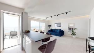 cocina y sala de estar con sofá azul en Luxury Penthouse Adriatic Blue - On the beach, en Tučepi