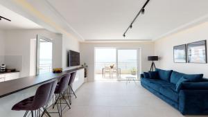 a living room with a blue couch and a counter at Luxury Penthouse Adriatic Blue - On the beach in Tučepi