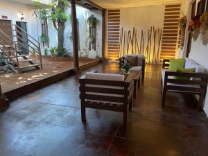 a living room with chairs and a table and stairs at Casa Hotel Santa Lucia in Suchitoto