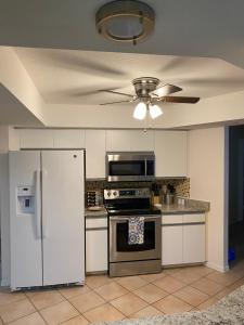 een keuken met een fornuis en een plafondventilator bij Private Heated Pool and Healing Waters Nearby in North Port