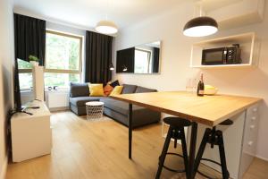 a kitchen and living room with a table and a couch at Sunrise Sopot Apartments in Sopot