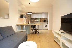 a living room and kitchen with a couch and a table at Sunrise Sopot Apartments in Sopot