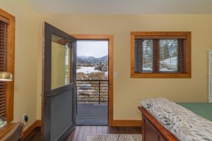 Schlafzimmer mit einer Tür, die auf einen Balkon führt in der Unterkunft Modern Grand Lake Luxury in Grand Lake