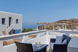 d'un balcon avec une table et des chaises donnant sur l'océan. dans l'établissement Cactus Guesthouse, Κίνι Συρος, à Kinion