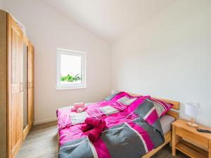 a bedroom with a bed with pink and gray sheets at Ferienhaus Eifelruhe in Filz in Filz