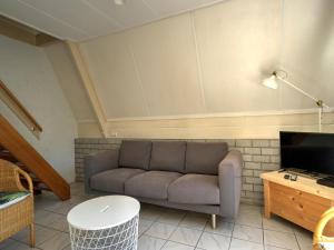 een woonkamer met een bank en een tv bij Cosy holiday home in Eerbeek with balcony terrace in Eerbeek