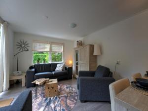- un salon avec deux canapés bleus et une table dans l'établissement Cosy holiday home in Hattemerbroek with garden, à Hattemerbroek