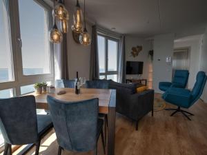 een woonkamer met een tafel en blauwe stoelen bij Premium apartment in Scherpenisse with roofed terrace in Scherpenisse