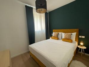 a bedroom with a bed with a green accent wall at Mediterra 2 in Crikvenica