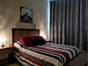 una camera con un letto con una coperta a righe di Cómodo departamento a Papantla de Olarte