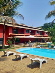 un complexe avec une piscine et un bâtiment rouge dans l'établissement Sarandy Hotel Eco Parque, à Paraíba do Sul
