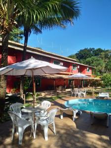 um pátio com uma mesa e cadeiras e uma piscina em Sarandy Hotel Eco Parque em Paraíba do Sul