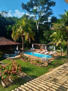 una piscina en un patio con palmeras en Sarandy Hotel Eco Parque, en Paraíba do Sul