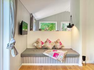 a small room with a bed with pillows on it at Holiday home Gilleleje LXXXIII in Gilleleje