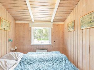 ブラーバンドにあるThree-Bedroom Holiday home in Blåvand 3の窓付きの部屋にベッド付きのベッドルーム1室があります。