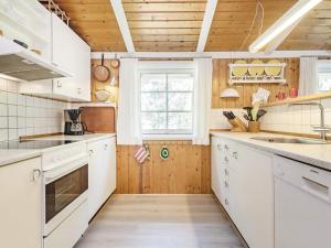 une cuisine avec des armoires blanches et une fenêtre dans l'établissement 6 person holiday home in Blåvand-By Traum, à Blåvand 31 autres photos