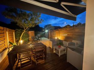 a wooden deck with a table and chairs on it at Le Chai de l'Océan - Studio Avec jardin et terrasse - plage 300 m in Soulac-sur-Mer