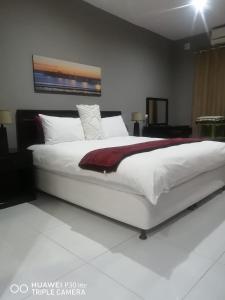 a bedroom with a large white bed with a red blanket at The Penthouse in Port Edward