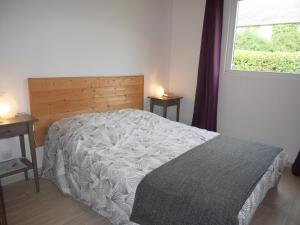 een slaapkamer met een bed met een houten hoofdeinde en een raam bij Wooden house near the sea, Landéda in Landéda