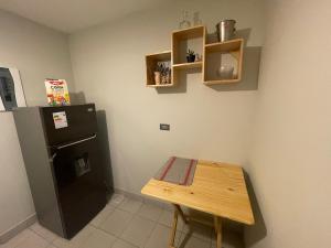Una pequeña cocina con una mesa y un refrigerador. en Departamento completo en Miraflores Surquillo, en Lima 4 fotos más