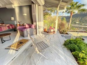 patio z kanapą, stołem i łóżkiem w obiekcie Blue Room in a shared Villa Diamant with communal pool and sea view w mieście Grand Case