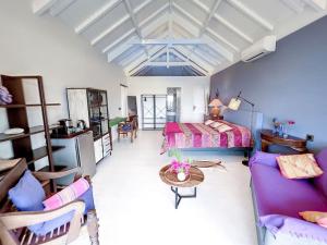 格蘭德凱斯的住宿－Blue Room in a shared Villa Diamant with communal pool and sea view，一间卧室配有一张床、一张沙发和一张桌子