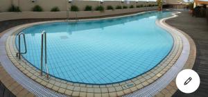a large swimming pool with blue water at Riverbank Suites apartment in Kuching