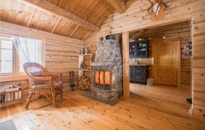 un soggiorno con stufa a legna in una baita di tronchi di Lovely Home In Rendalen With Kitchenette a Rendalen