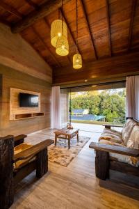 a living room with a couch and a tv at Pousada Trem Chic in Poços de Caldas