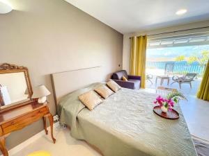 a bedroom with a bed and a table with flowers on it at Frangipani Room in shared Villa Diamant, swimming pool, sea view in Grand Case
