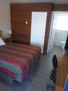 a hotel room with a bed and a desk and a chair at Southsider Motel in Coos Bay
