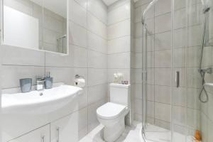 y baño con aseo, lavabo y ducha. en City Sparrow Apartments 6 en Londres
