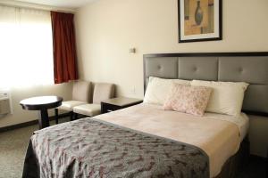 Habitación de hotel con cama y silla en American Travel Inn en Pullman