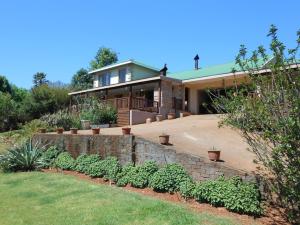 a house with a retaining wall and some plants at Two Falls View in Sabie