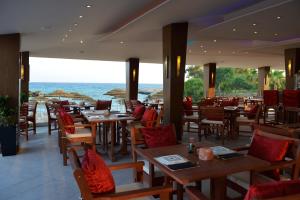 a restaurant with tables and chairs and a view of the ocean at Adams Beach Hotel & Spa in Ayia Napa