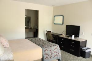 Habitación de hotel con cama y TV en American Travel Inn, en Pullman