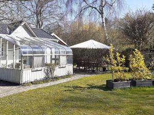 a greenhouse in a yard with a table and chairs at Holiday home Taastrup in Tåstrup