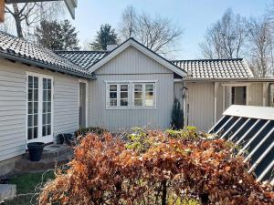 una pequeña casa con un jardín frente a ella en Holiday home Taastrup, en Tåstrup