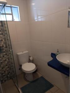 a bathroom with a toilet and a sink at Kitnet Recanto de Campos-Pertinho do Centro in Campos do Jordão