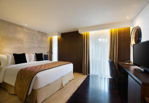 Postel nebo postele na pokoji v ubytování de Vins Sky Hotel Seminyak