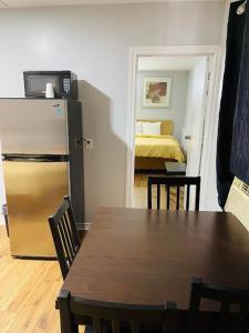 uma cozinha com uma mesa e um frigorífico e um quarto em A1 Inn em Cataratas do Niágara