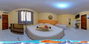 um quarto com uma grande cama branca num quarto em Pousada Sonho de Mar em Luís Correia