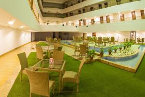 a restaurant with tables and chairs and a pool at Velvet Clarks Exotica in Chandīgarh