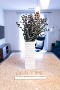 a white vase with flowers sitting on a table at AMPLIFY SPACES 1 and 2 BR Apartments, Downtown Birmingham, UAB in Birmingham