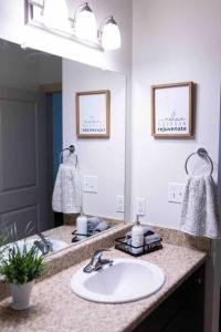 a bathroom with a sink and a mirror at AMPLIFY SPACES 1 and 2 BR Apartments, Downtown Birmingham, UAB in Birmingham