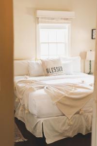 a bedroom with a large white bed with a window at La Villa de Adelina in Ensenada